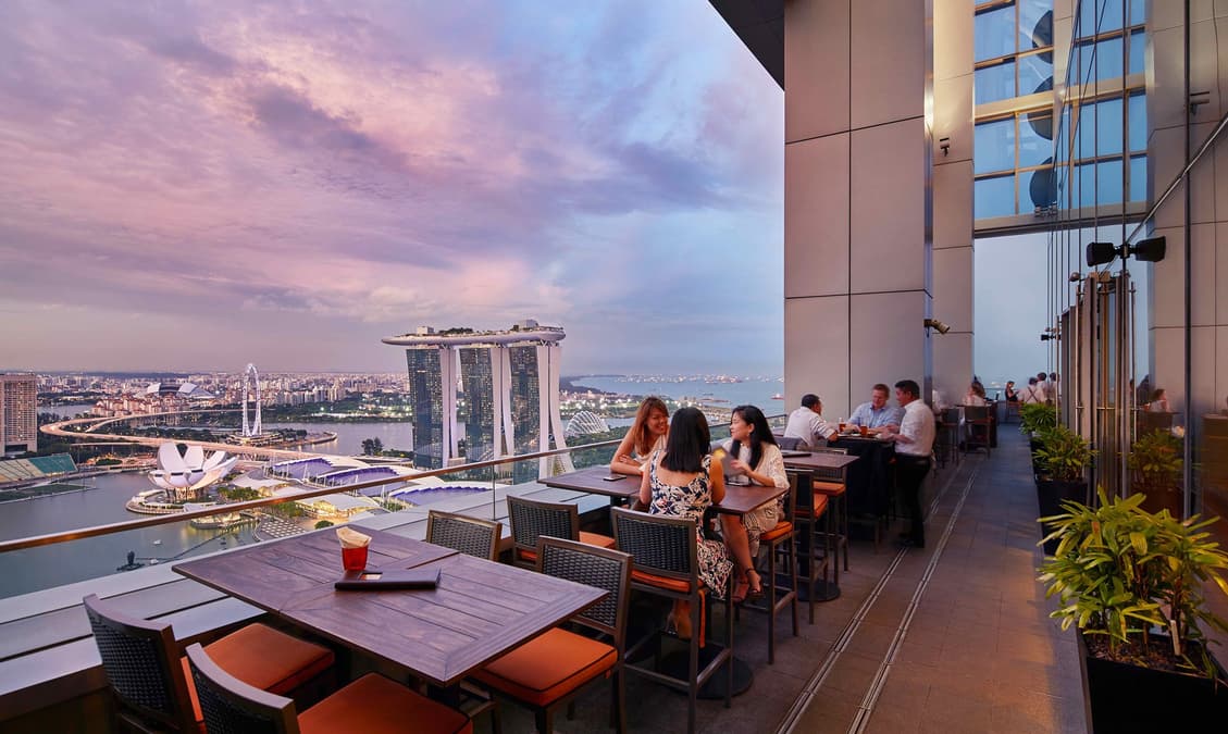 Fine dining table at Singapore rooftop restaurant with skyline view — luxury dining Singapore